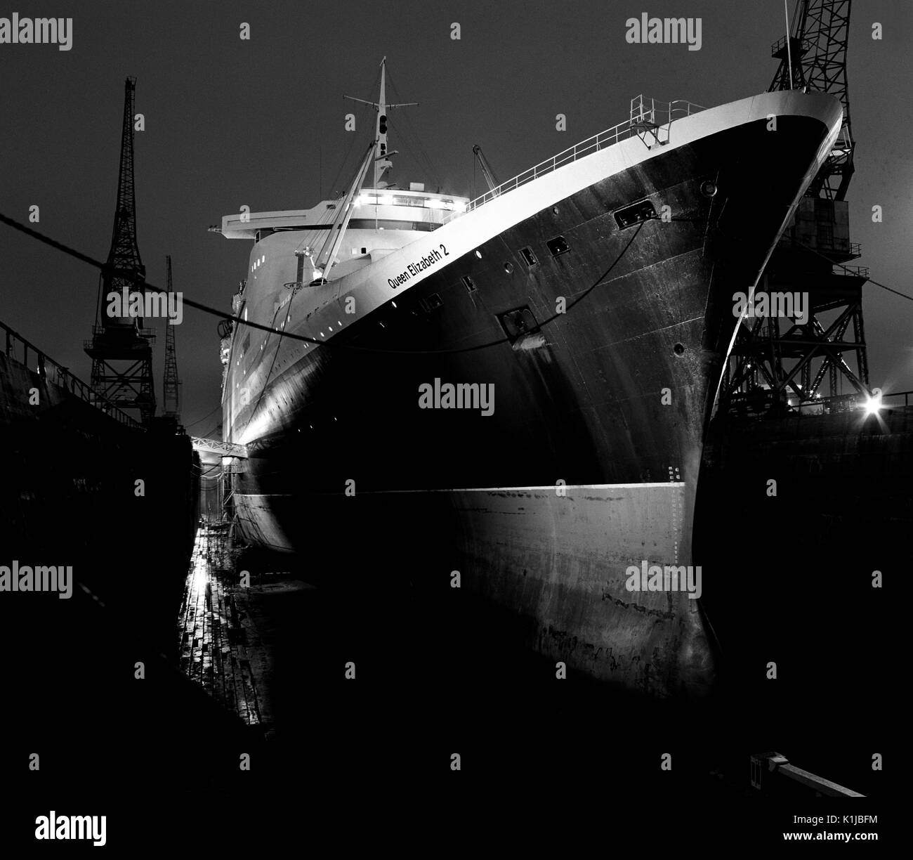 Photographie de nuit QE2 dans le King George V dock sec. à quais de Southampton, Southampton, Hampshire, Angleterre, où elle a d'atterrissage pour hélicoptères équipés pour le service dans la guerre des Malouines - Mai 1982 Banque D'Images