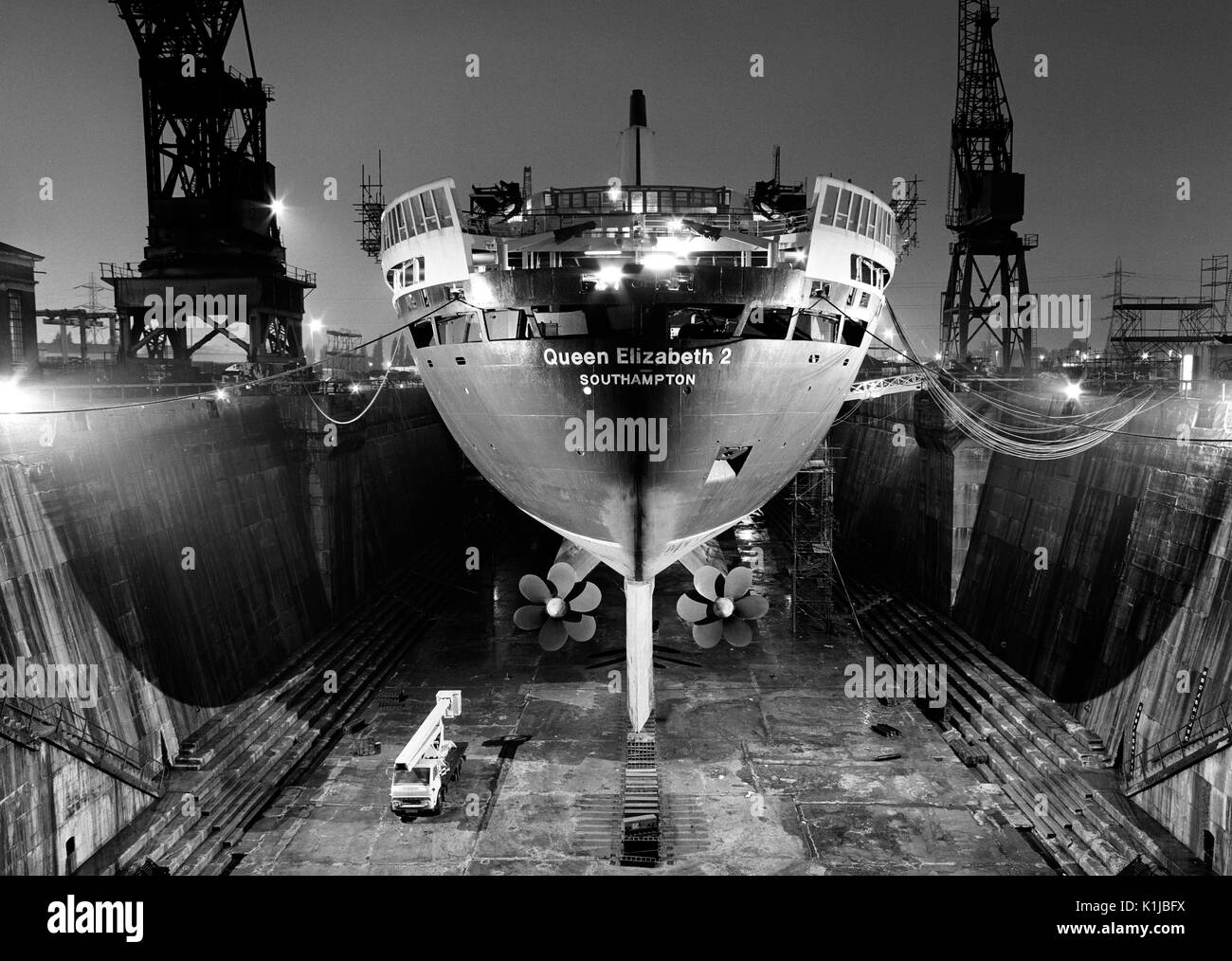 Photographie de nuit QE2 dans le King George V dock sec. à quais de Southampton, Southampton, Hampshire, Angleterre, où elle a d'atterrissage pour hélicoptères équipés pour le service dans la guerre des Malouines - Mai 1982 Banque D'Images