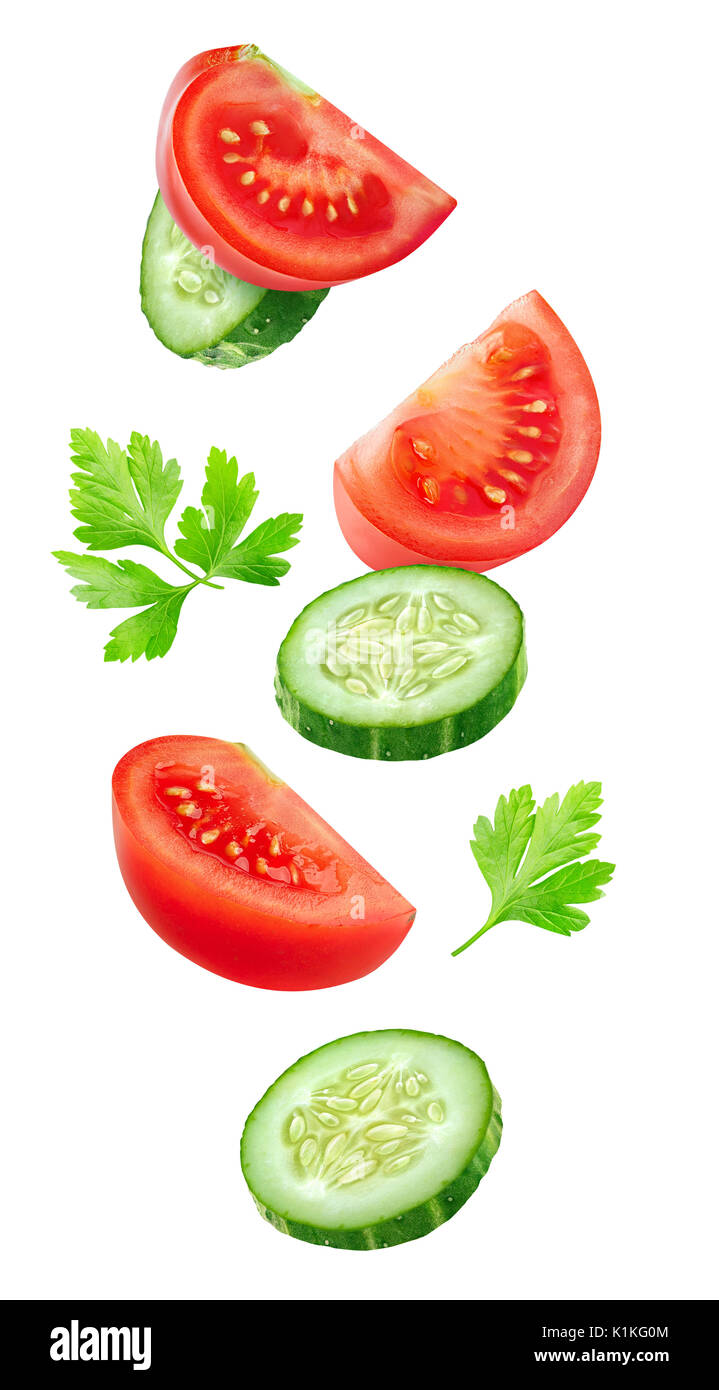 Légumes isolées. Technique mixte des tranches de concombre et de tomate dans l'air isolé sur blanc avec clipping path Banque D'Images