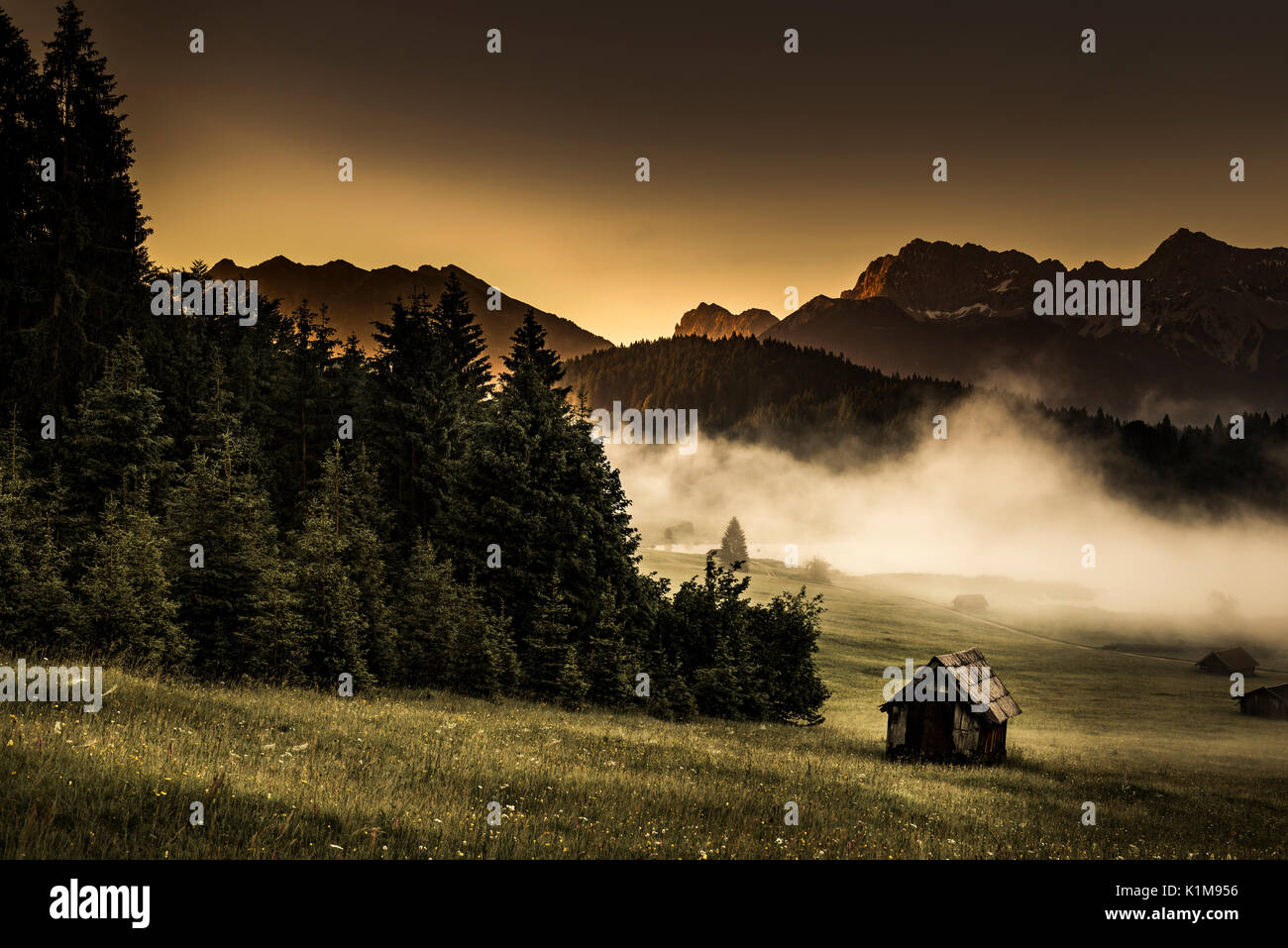 Petit chalet en montagne au bord de la forêt, prairie Geroldsee en arrière-plan des Karwendel à sunrise, Kaltenbrunn Banque D'Images