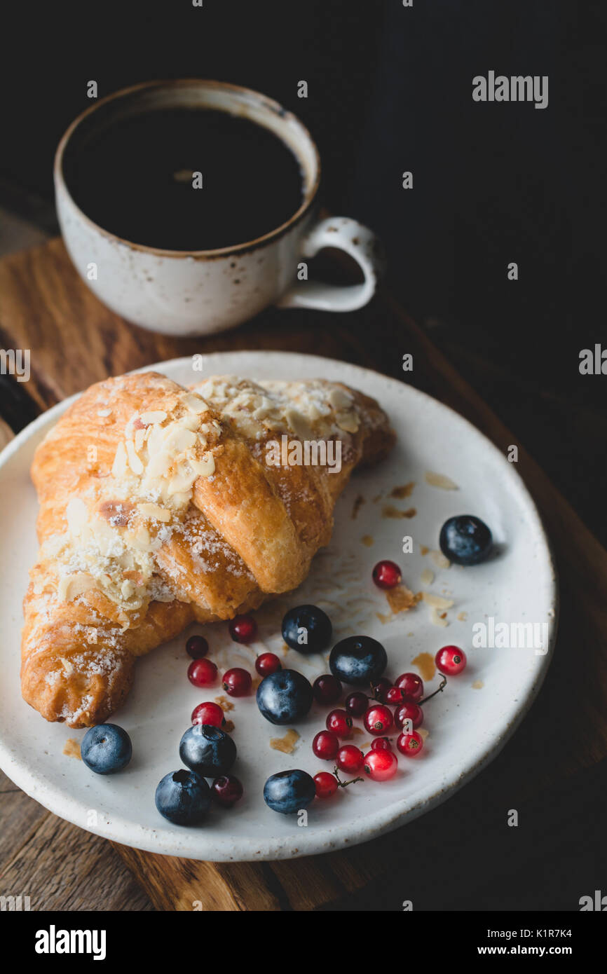 Croissant aux amandes, des petits fruits et une tasse de café. vue  rapprochée, tonique libre Photo Stock - Alamy