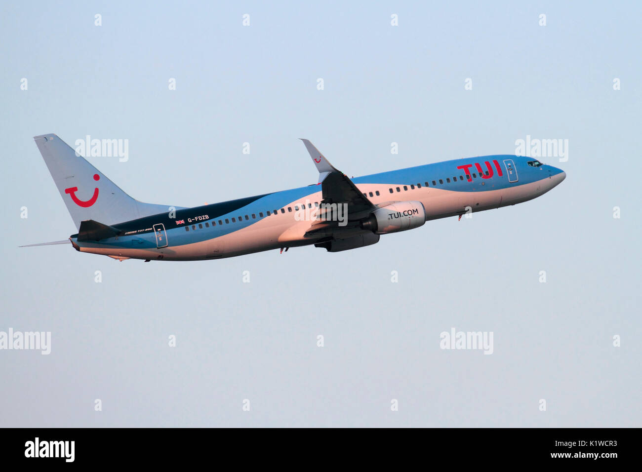 Le transport aérien commercial. TUI Airlines UK (anciennement Thomson Airways Boeing 737-800) Avion de ligne volant dans le ciel sur le départ au coucher du soleil Banque D'Images