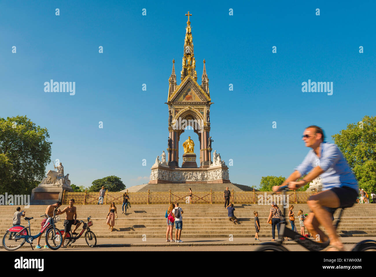 Vélo d'été de Londres, par un après-midi d'été les touristes à vélo Visitez le Mémorial Albert à l'entrée des Jardins de Kensington, London,UK Banque D'Images
