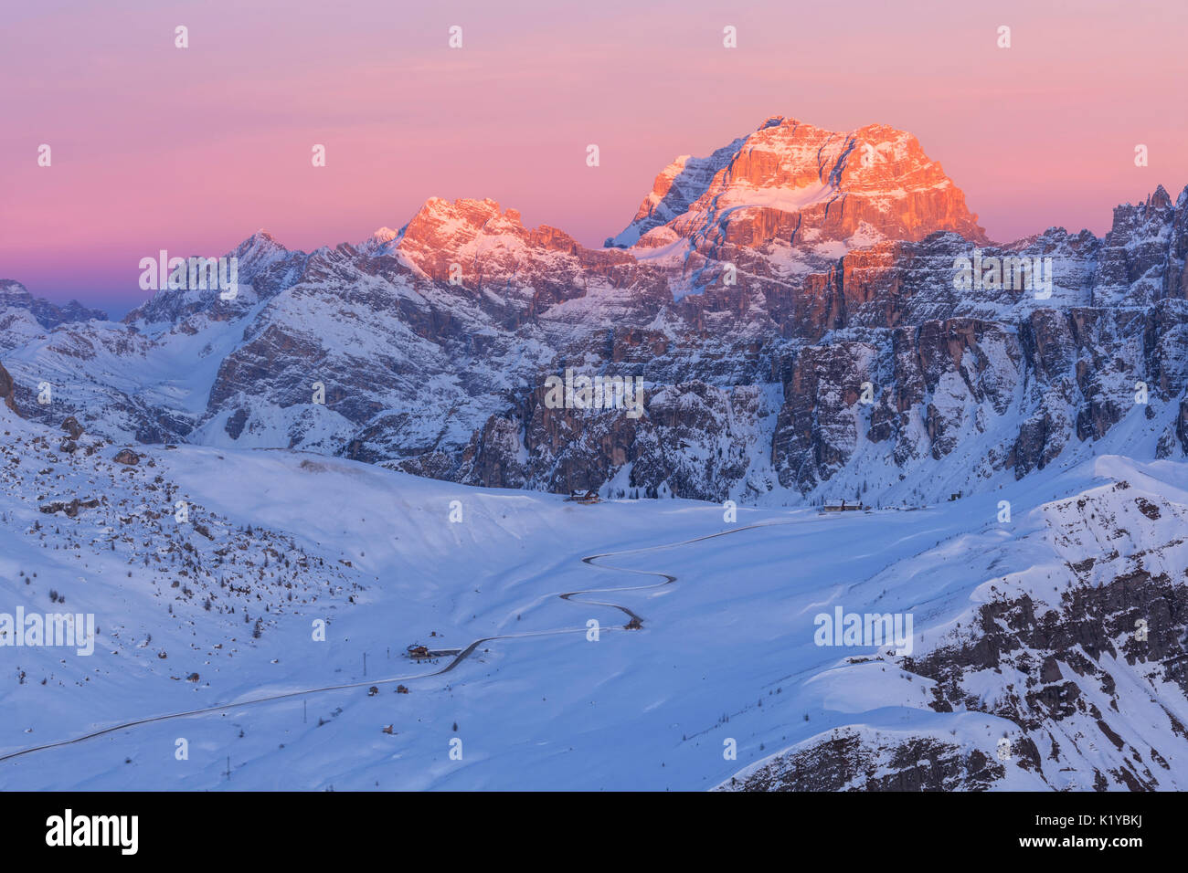 La route qui va à Passo Giau lors d'un coucher de soleil d'hiver. Dans l'arrière-plan Sorapiss éclairées par les derniers rayons du soleil au crépuscule. Dolomites, Veneto, Italie Banque D'Images