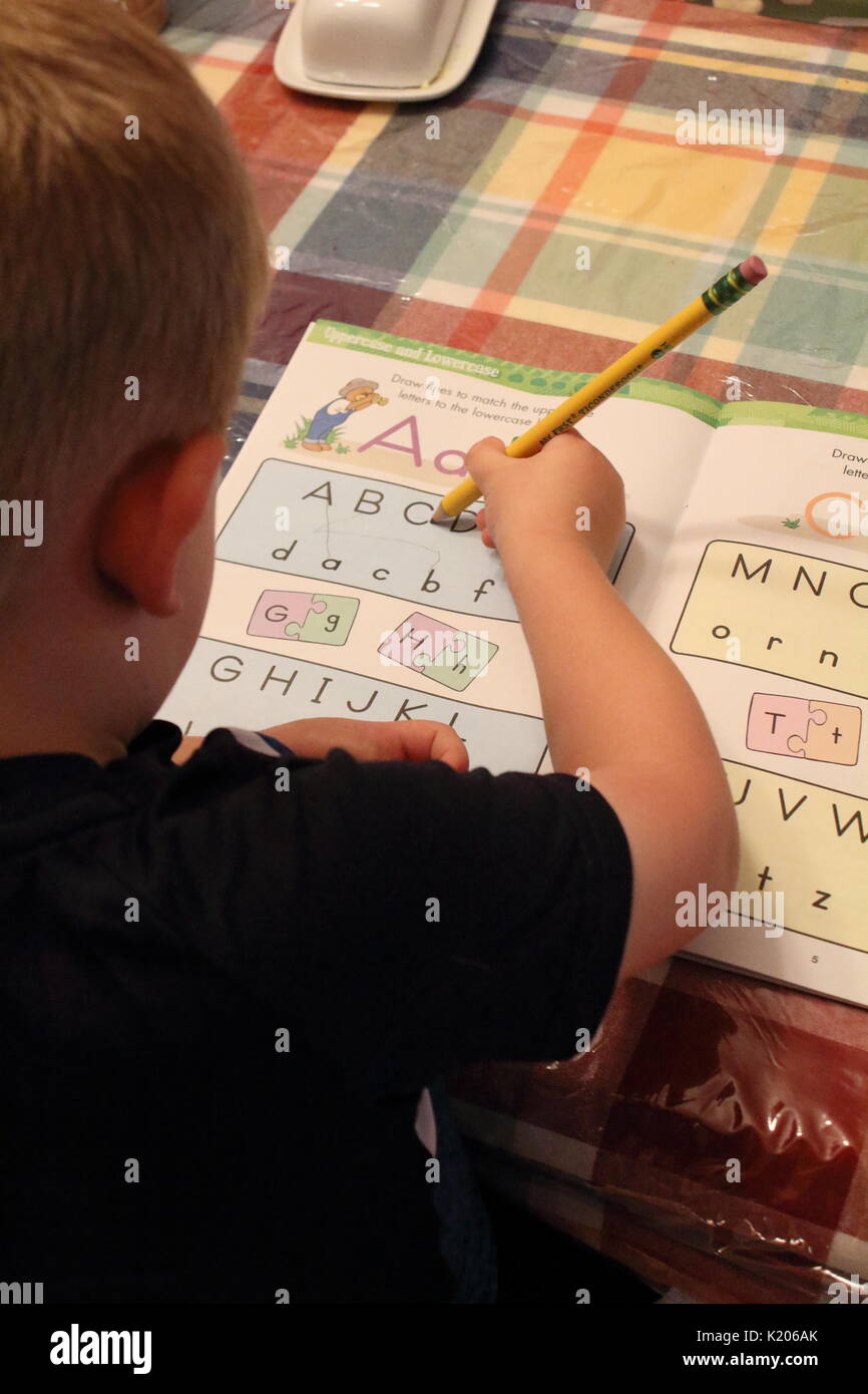 Garçon d'âge préscolaire à apprendre à écrire des lettres Banque D'Images