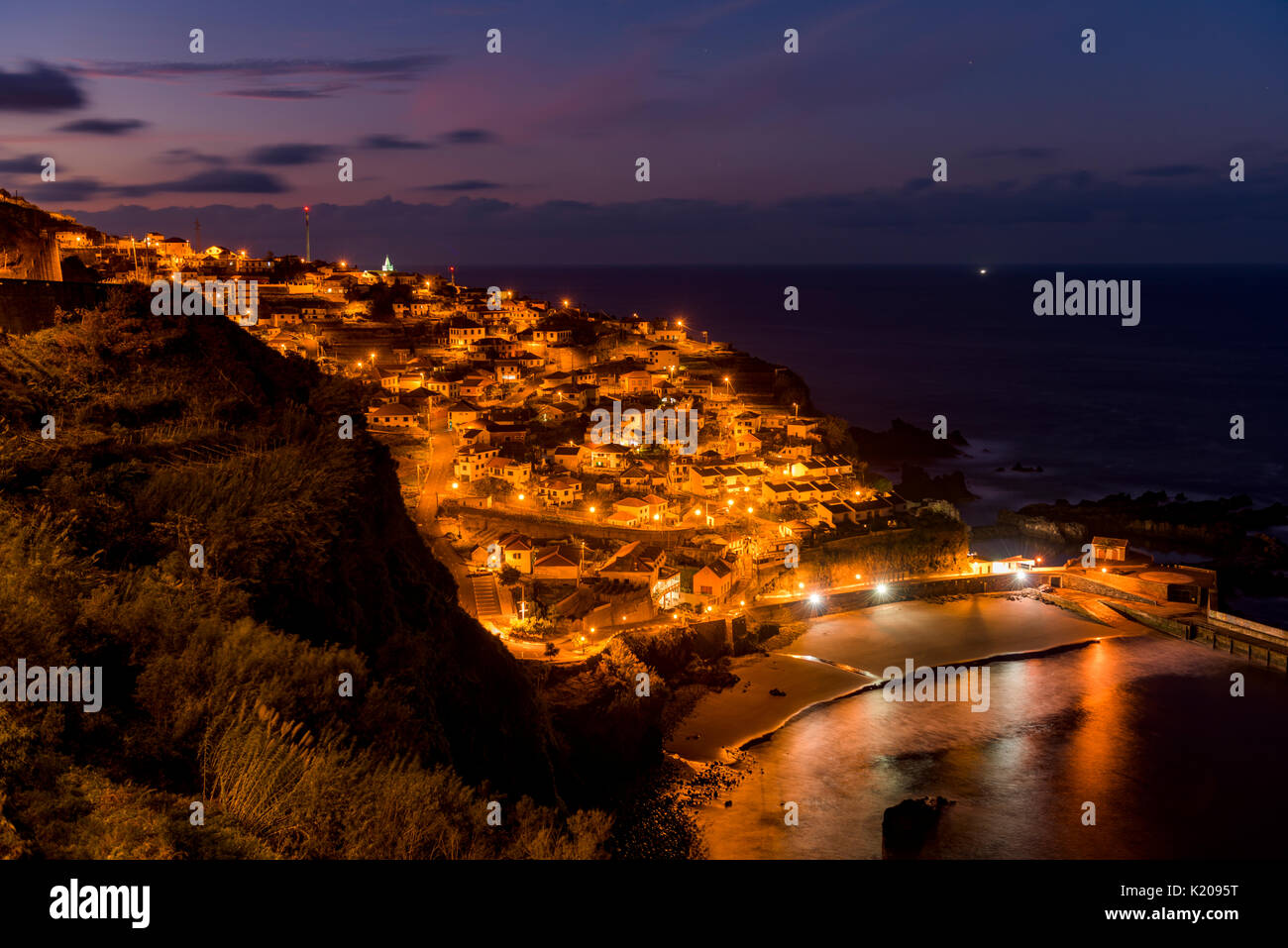 Heure bleue avec la ville illuminée par la mer, Seixal, Madeira, Portugal Banque D'Images