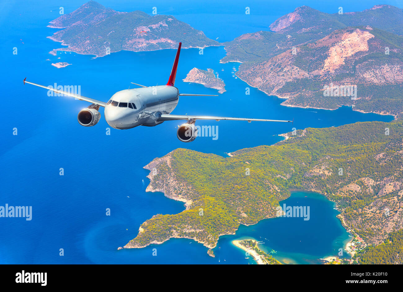 C'est avion survolant les îles étonnantes et mer méditerranée à bright day. Paysage avec montagnes, avion passager blanc et bleu de l'eau. Passen Banque D'Images