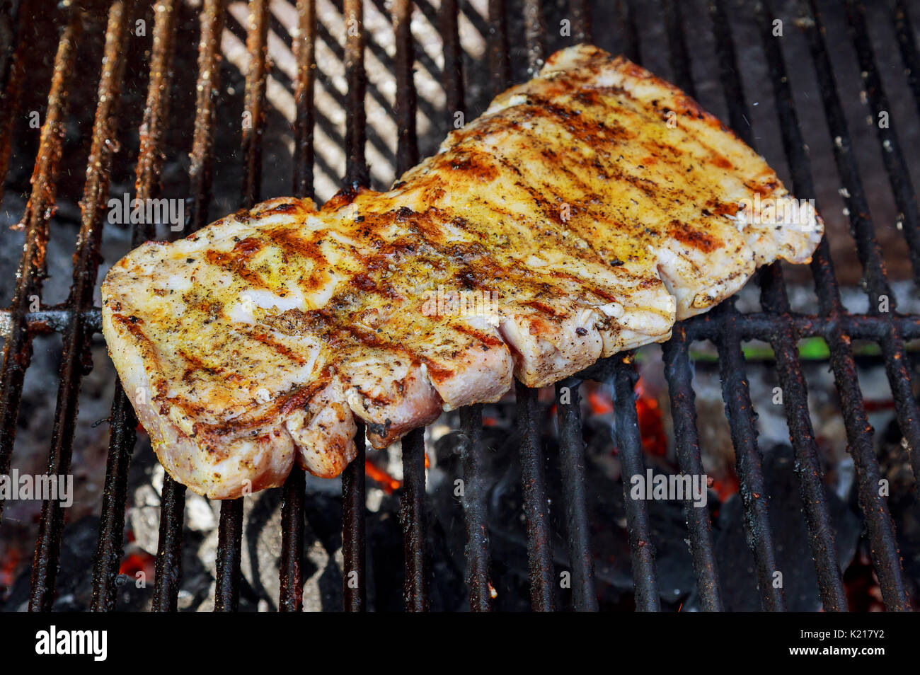 Steak brûle sur le feu de cuisson Chef un steak de boeuf sur feu ouvert barbecue. Banque D'Images