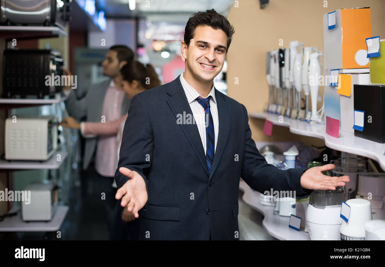 Smiling spanish shop assistant travailler avec le client à petits appareils ménagers section. L'accent sur le vendeur Banque D'Images