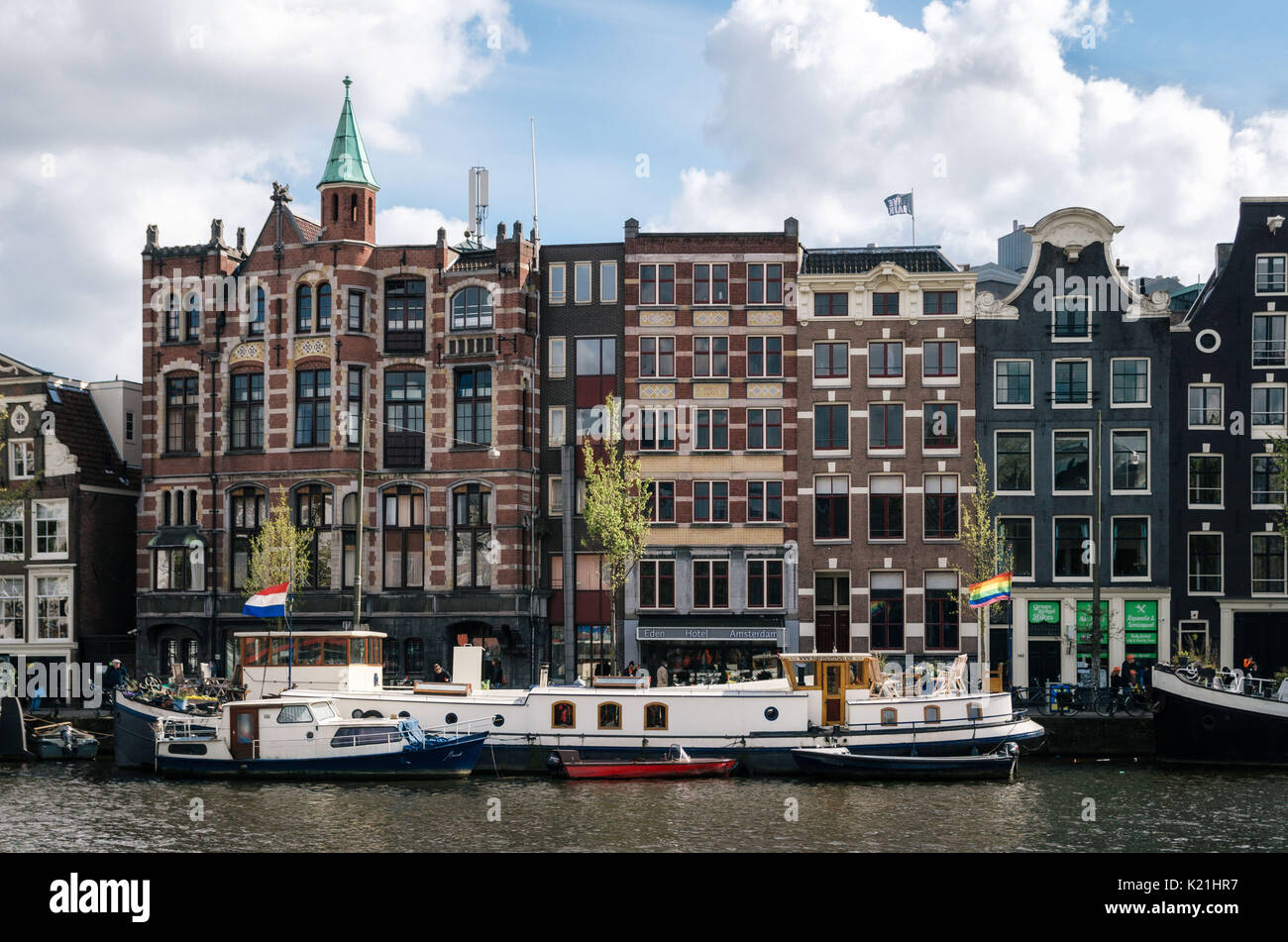 Amsterdam, Pays-Bas - 27 avril, 2017 : péniches et barges vivant dans Binnenamstel contre canal néerlandais typiques maisons avec pavillon de l'Allemagne et Banque D'Images
