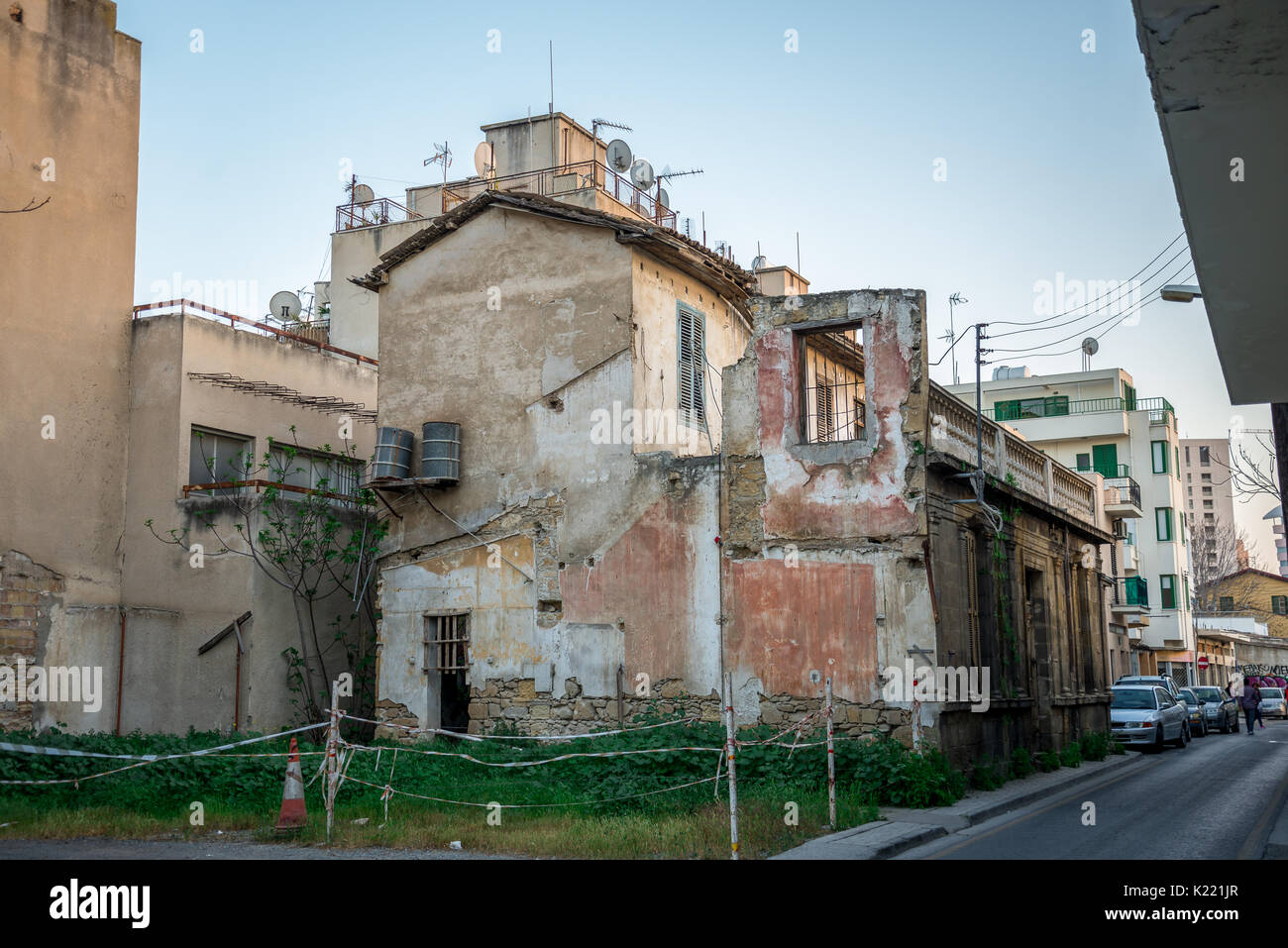 Une maison avec des murs brisés et à l'extérieur des barils d'eau pour l'approvisionnement en eau dans le centre-ville de Nicosie, Chypre Banque D'Images