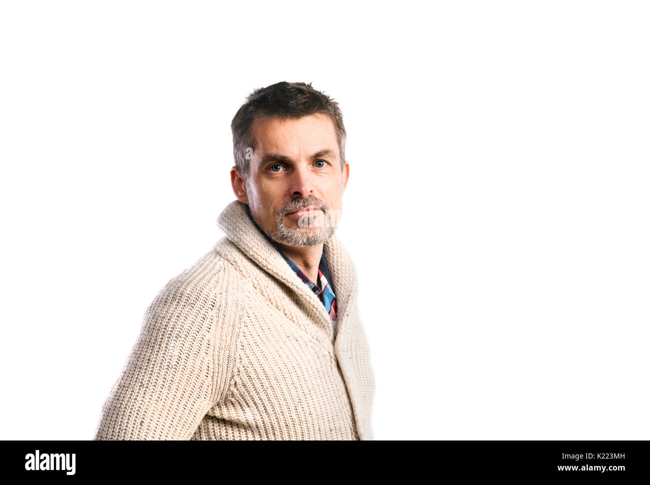 Homme mature hipster en beige pull. Studio shot, isolé. Banque D'Images