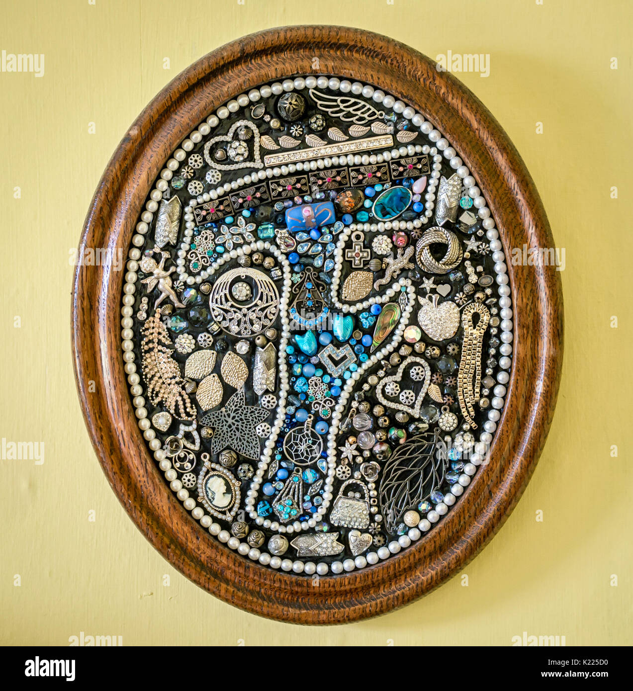 Œuvre d'art ovale personnalisée faite à la main, ornée de bijoux avec motif « F » en mosaïque et cadre vintage sur fond Uni coloré Banque D'Images