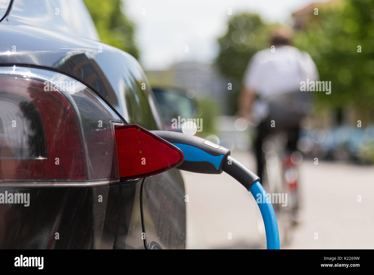 Bloc d'alimentation branché sur une voiture électrique en cours de charge. Banque D'Images