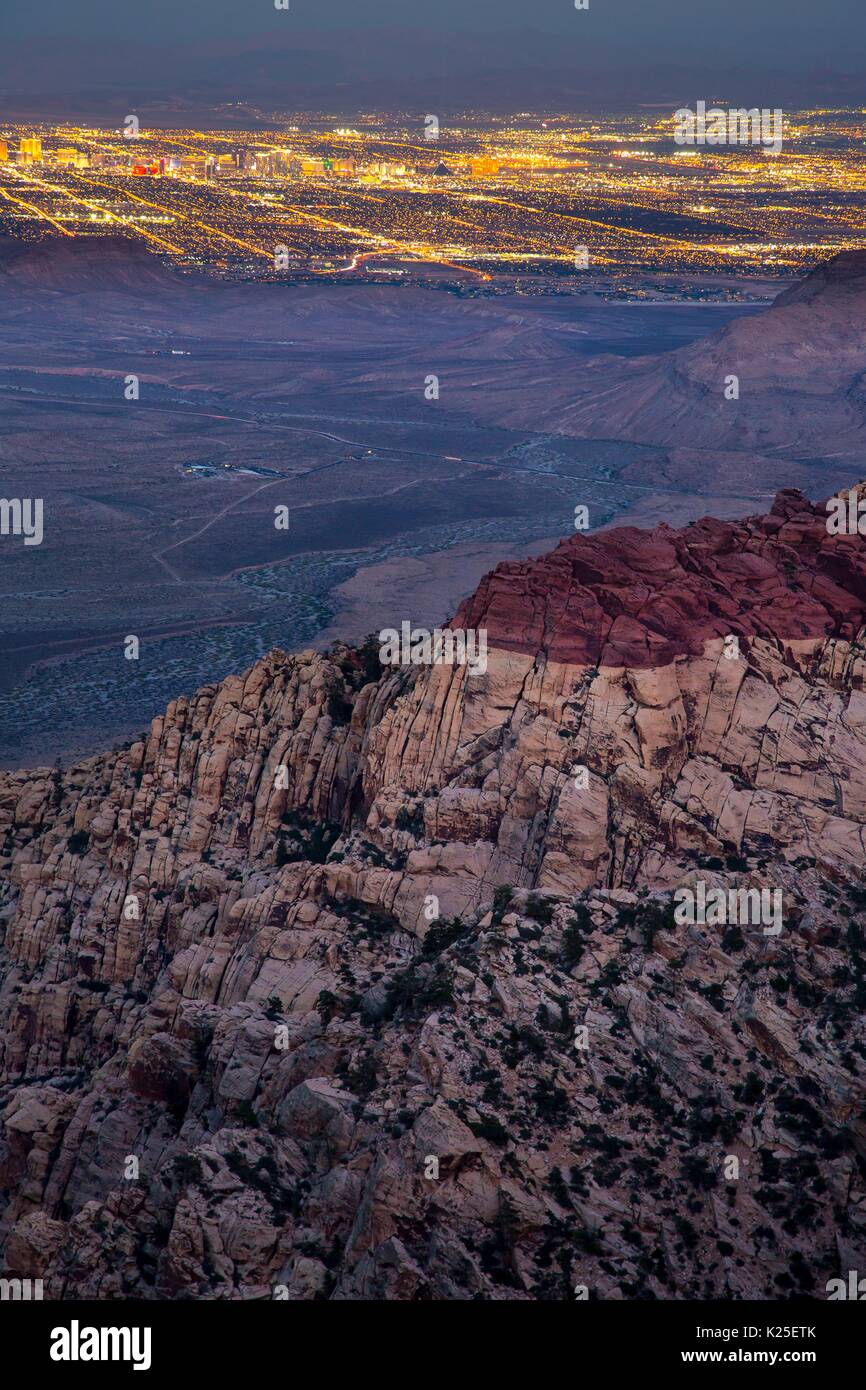 Des formations de roche rouge au Red Rock Canyon National Conservation Area avec les lumières de Las Vegas dans la distance le 26 septembre 2016 près de Las Vegas, Nevada. Banque D'Images