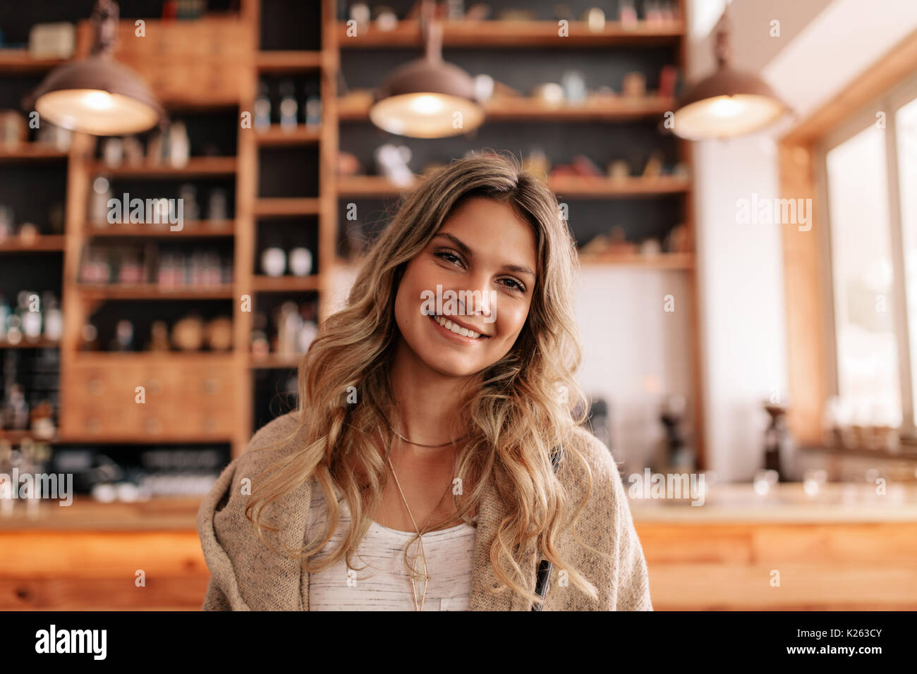Portrait de belle jeune femme debout dans un café. Les jeunes femmes de race blanche dans un café à la caméra et au sourire. Banque D'Images