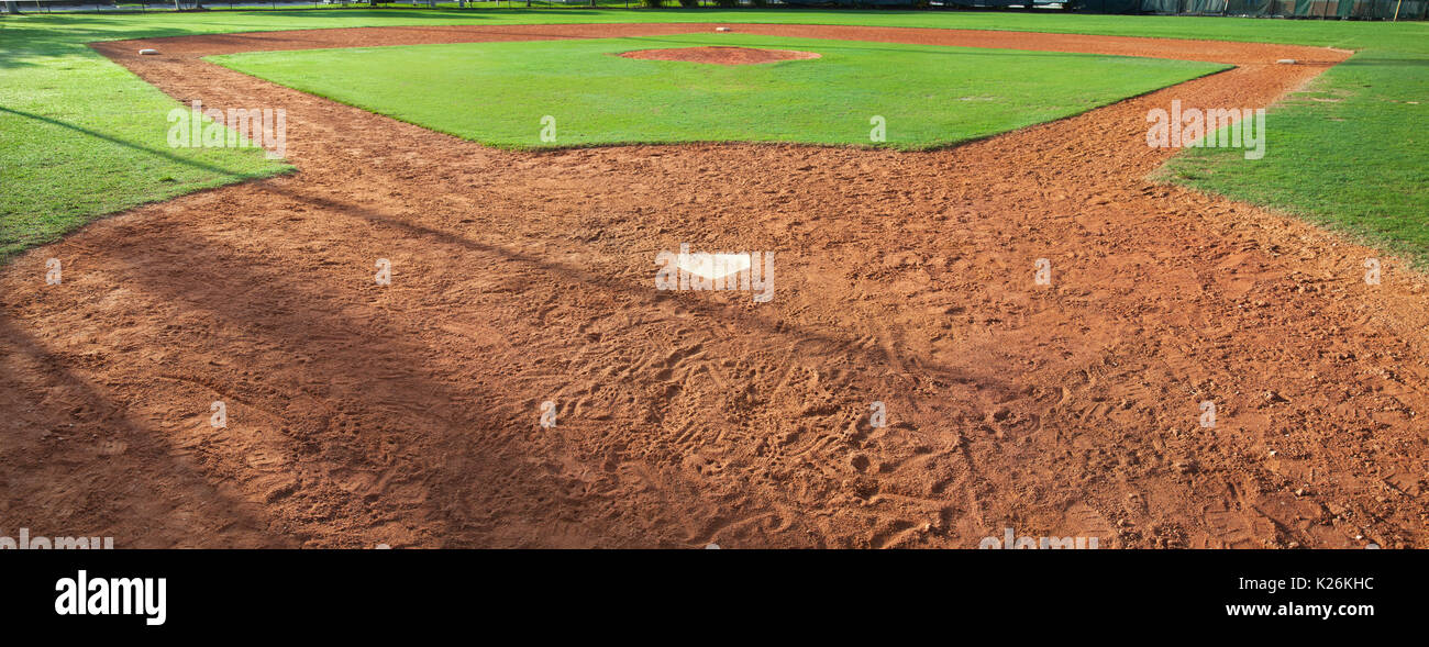Un terrain de baseball de la jeunesse vu de derrière la plaque dans la lumière du matin Banque D'Images