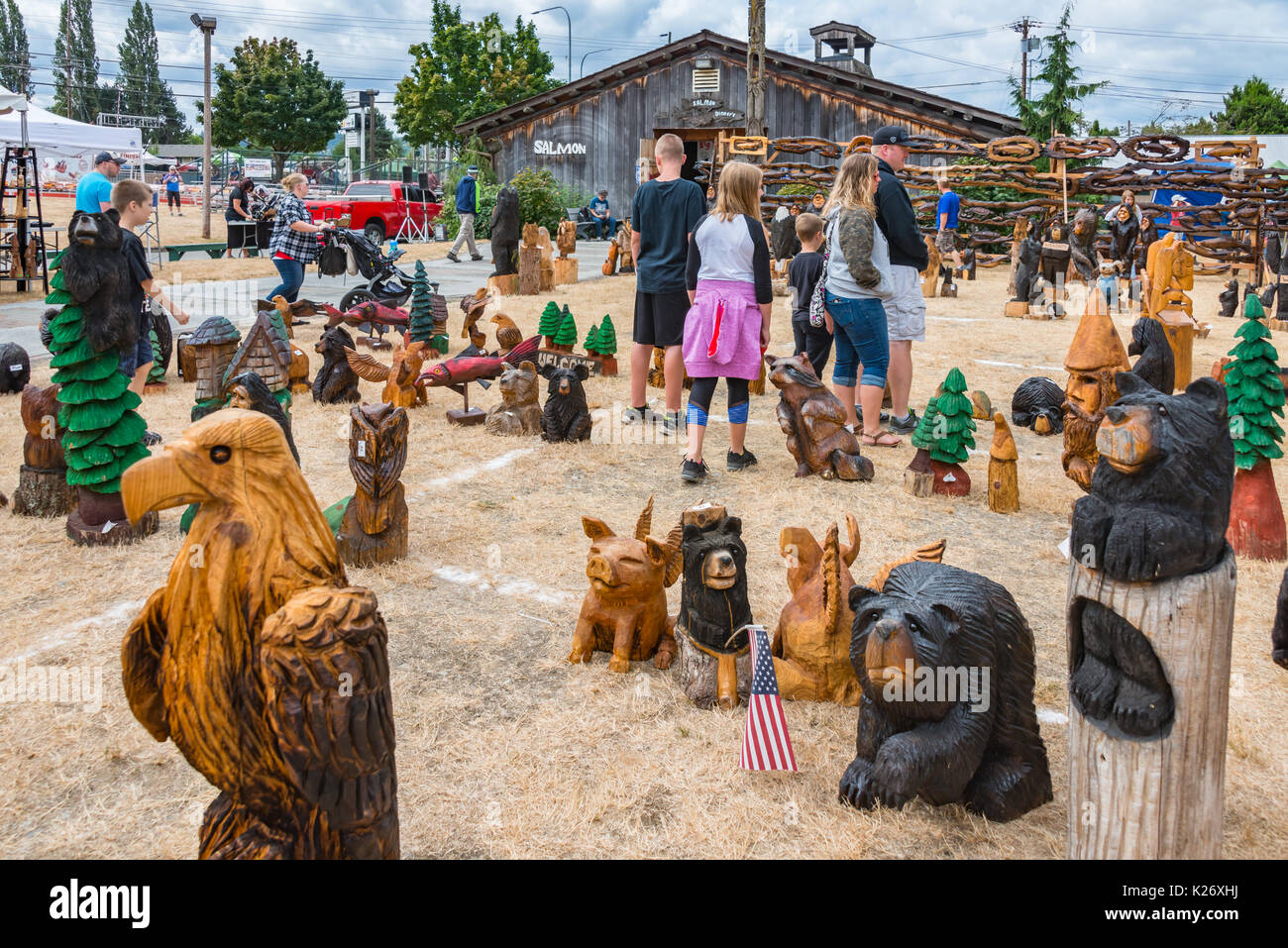 Visiteurs marche autour de pièces d'art à la tronçonneuse colorés Evergreen State Fair Monroe Washington Banque D'Images
