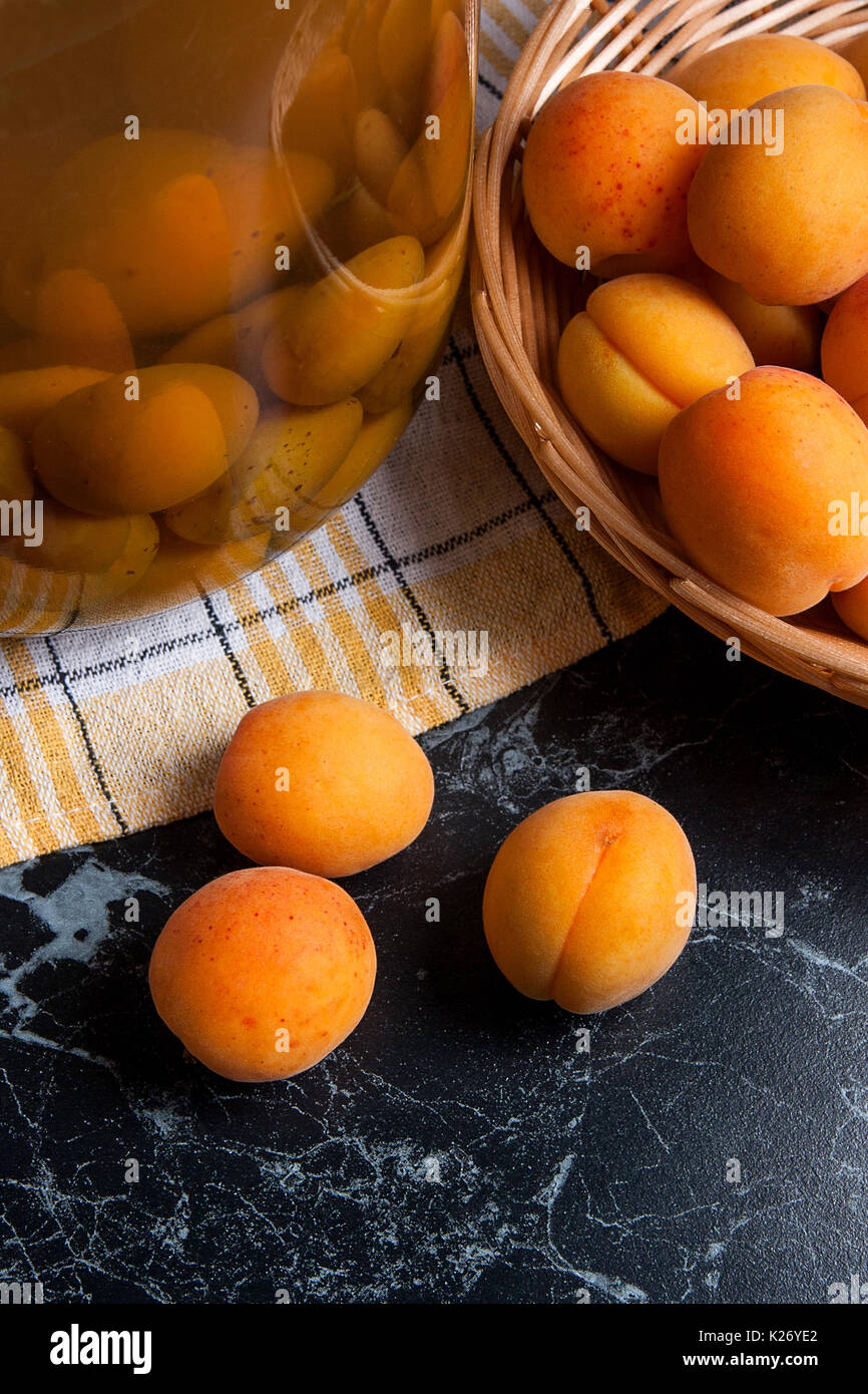 Les abricots bio mûres récoltées à l'heure d'été et grand bocal en