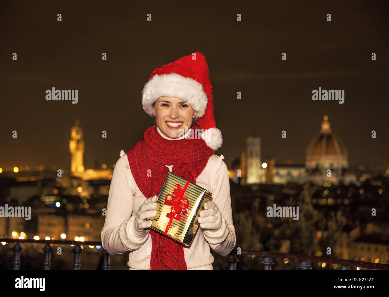 Voyage plein d'inspiration à l'époque de Noël à Florence. smiling young woman in Christmas hat à la Piazzale Michelangelo à Florence, Italie avec Christma Banque D'Images