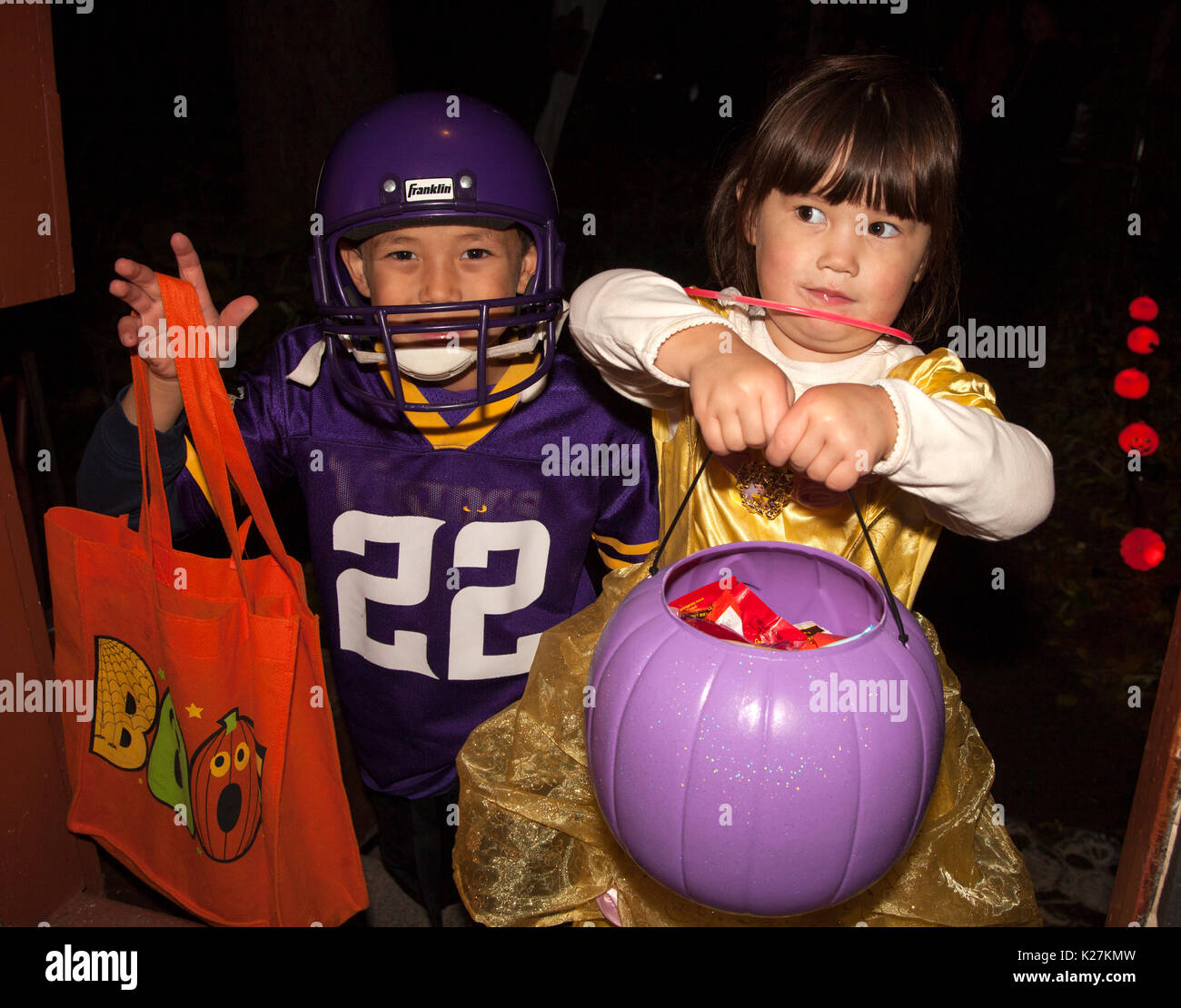 Et Halloween Halloween dans le football et danseuse costume avec une citrouille violet pour candy. St Paul Minnesota MN USA Banque D'Images