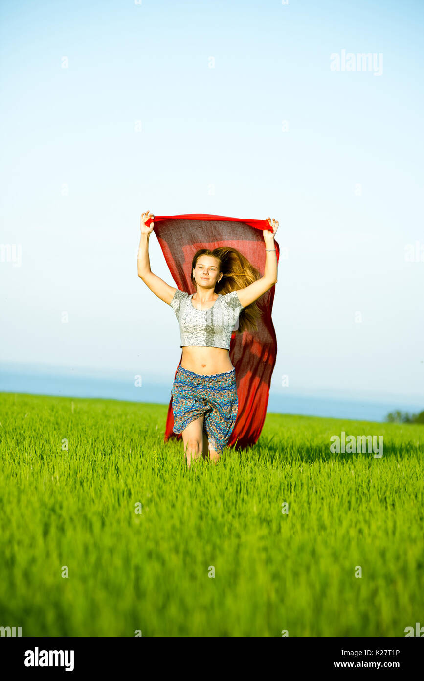 Jeune femme heureuse en champ de blé avec le tissu. Vie d'été Banque D'Images