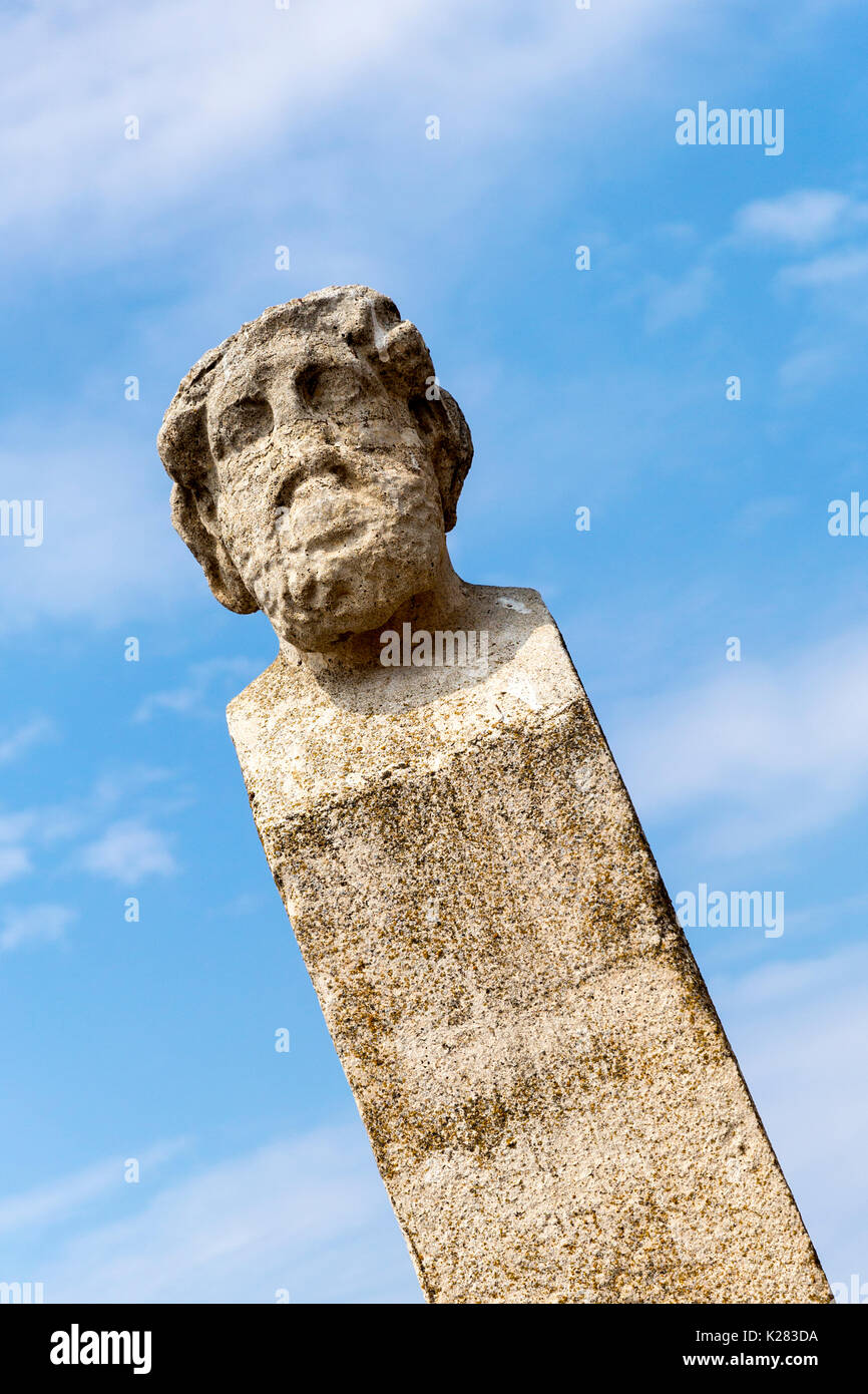 Colonne en marbre surmonté d'une tête en haut au milieu des ruines archéologiques, Delos, Grèce Banque D'Images