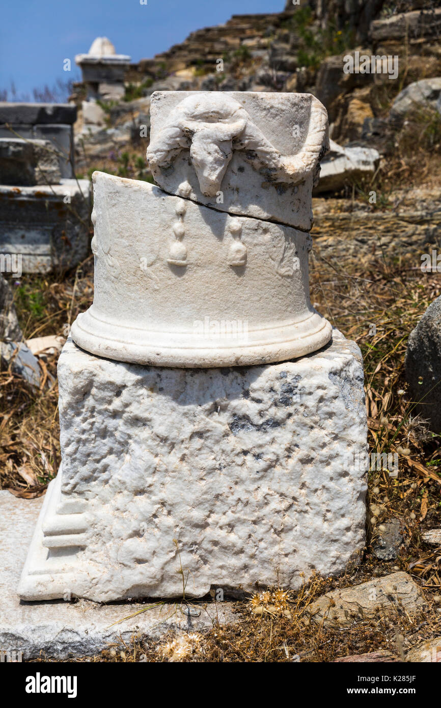 Pilier sculpté d'un casse tête de bélier parmi les nombreux vestiges de Delos, Cyclades, en Grèce. Banque D'Images