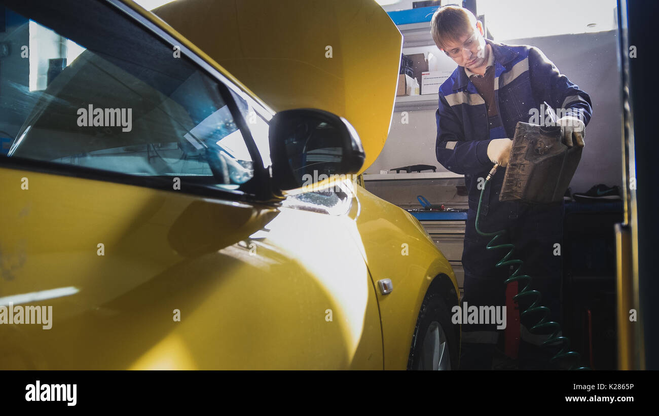 Mécanicien de voiture coups de filtre à air en service automobile Banque D'Images