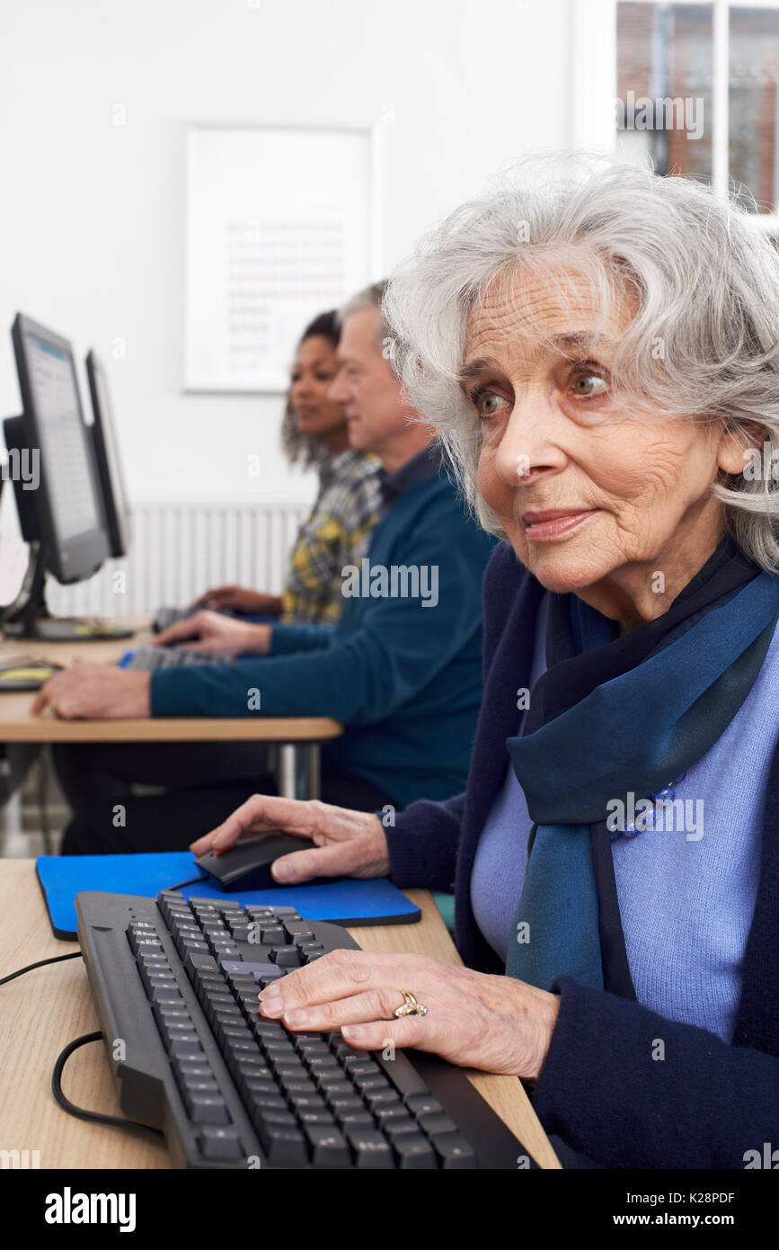 Femme Senior Assistant à Computer Class Banque D'Images