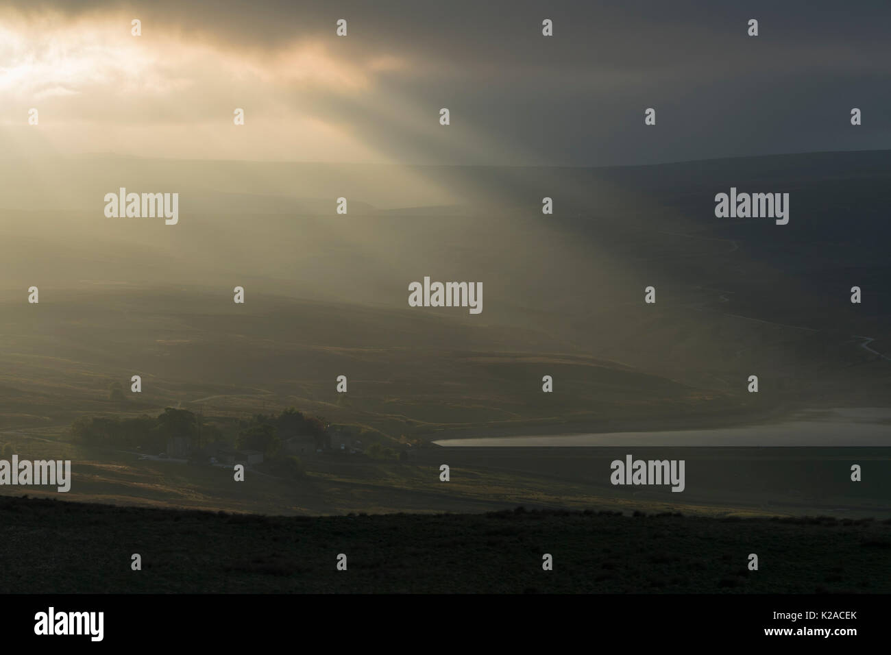 Rayons de soleil du soir sur le flux de sombres nuages sur le réservoir inférieur Barden & scenic campagne vallonnée - Wharfedale, Yorkshire, Angleterre, Royaume-Uni. Banque D'Images