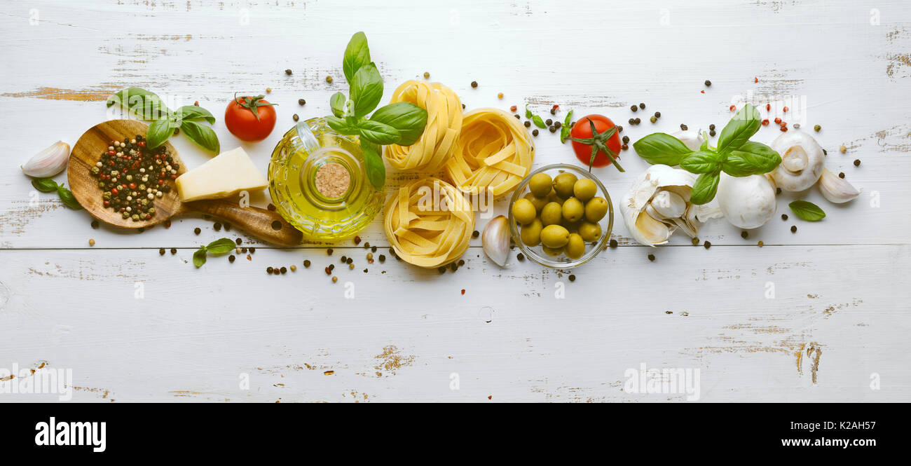 Les aliments ou ingrédients italien historique avec des légumes frais, des pâtes, du fromage parmesan et d'épices. Vue d'en haut Banque D'Images