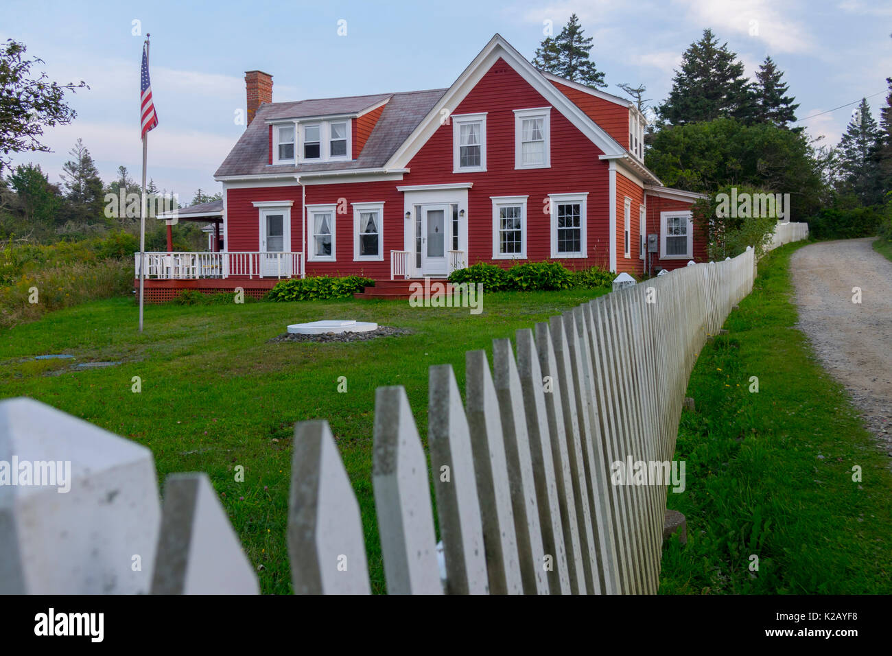 USA Maine moi île Monhegan la maison rouge sur le couvercle du homard route avec une clôture blanche Banque D'Images