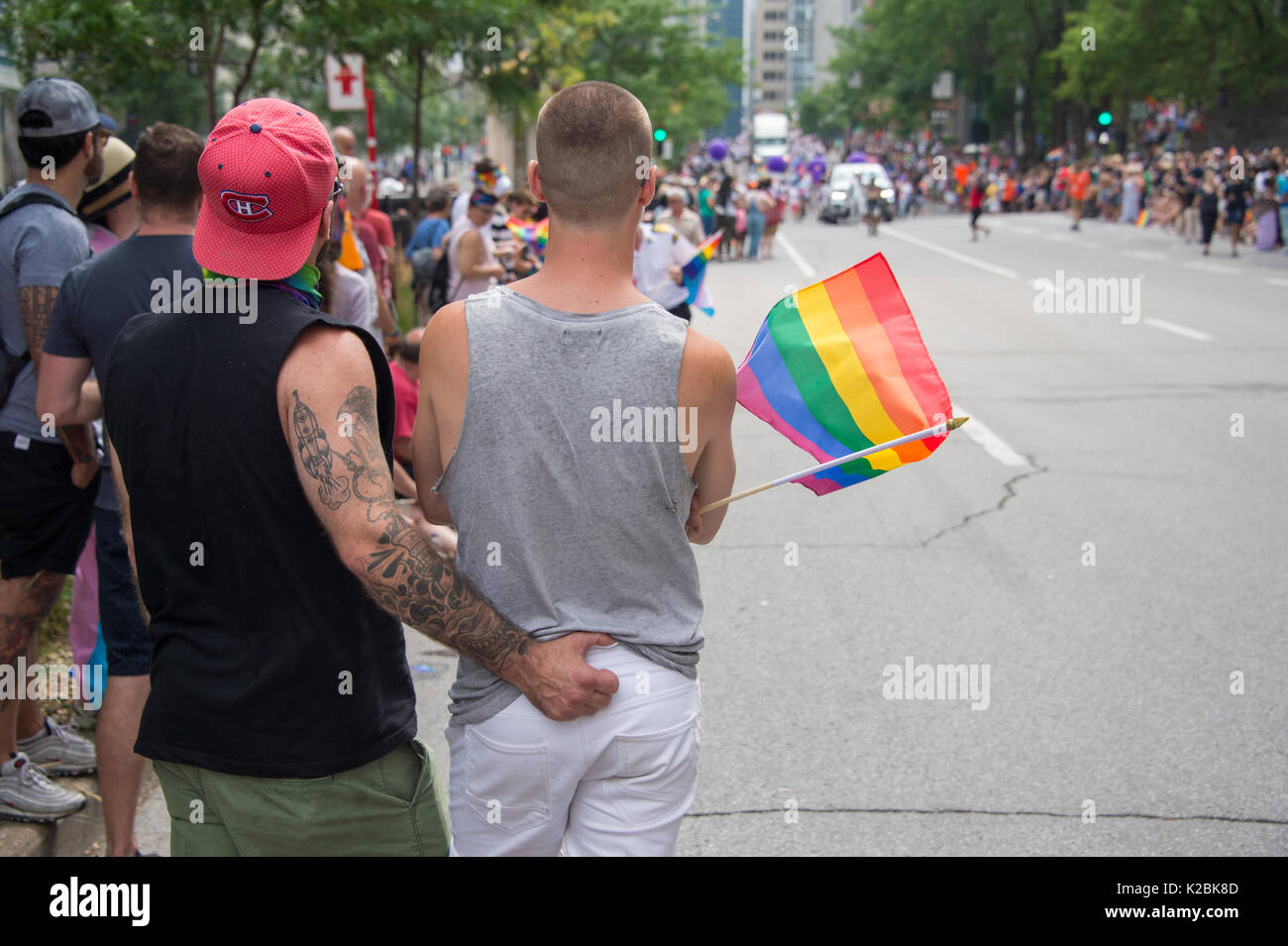 Montréal, Canada - 20 août 2017 : vue arrière d'un gay homme couple tenant un drapeau arc-en-ciel gay gay pride parade à Montréal Banque D'Images