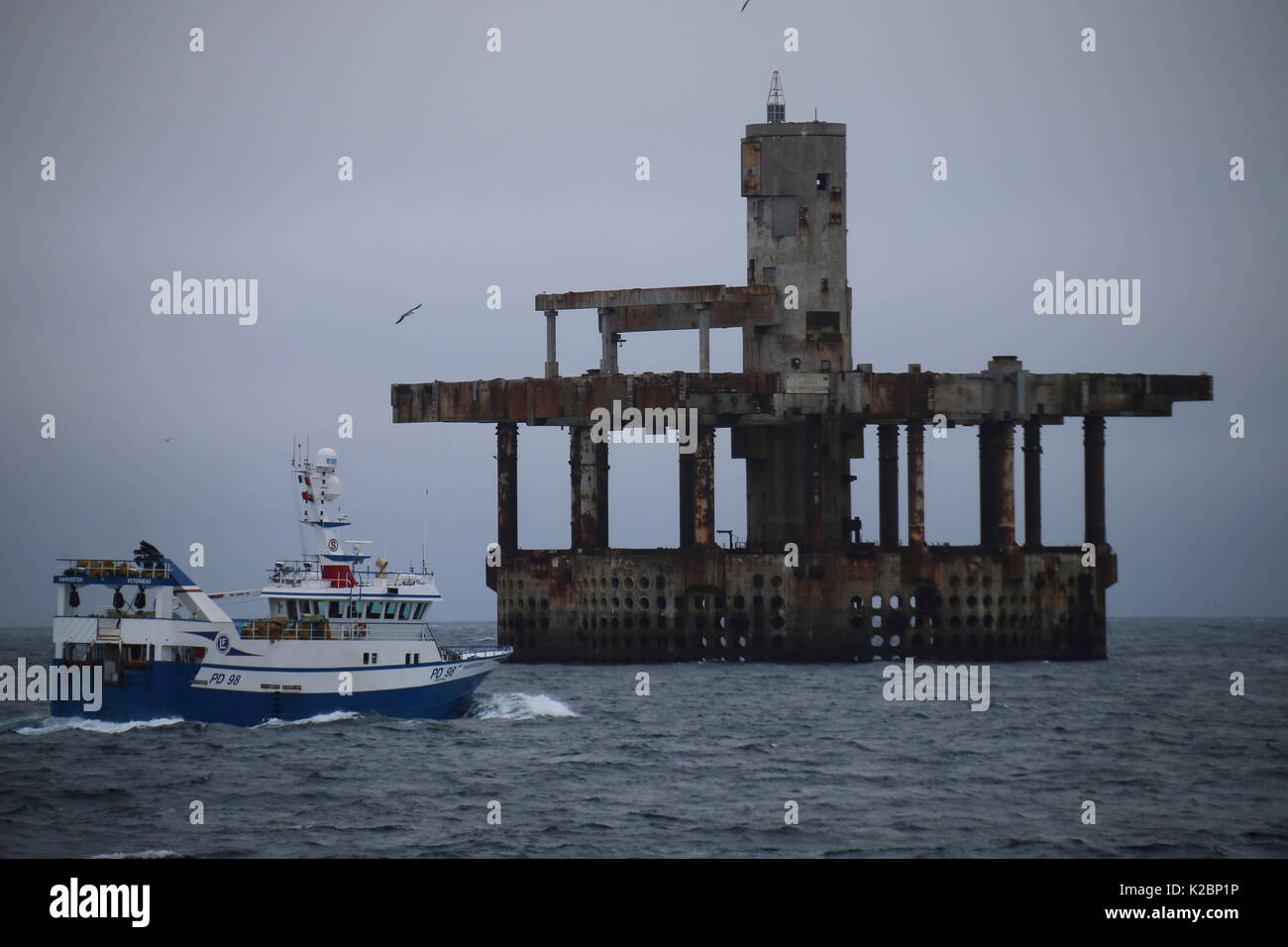 Station de pompage de pétrole abandonnés avec bateau de pêche, Mer du Nord, en juillet 2015. Banque D'Images