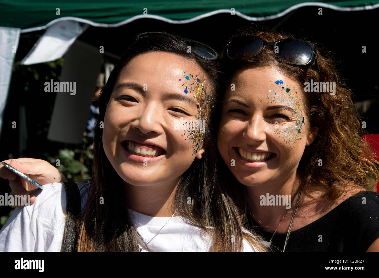 Août 2017 carnaval de Notting Hill. Deux jeunes femmes asiatiques visiter Londres avec glitter make-up. Banque D'Images