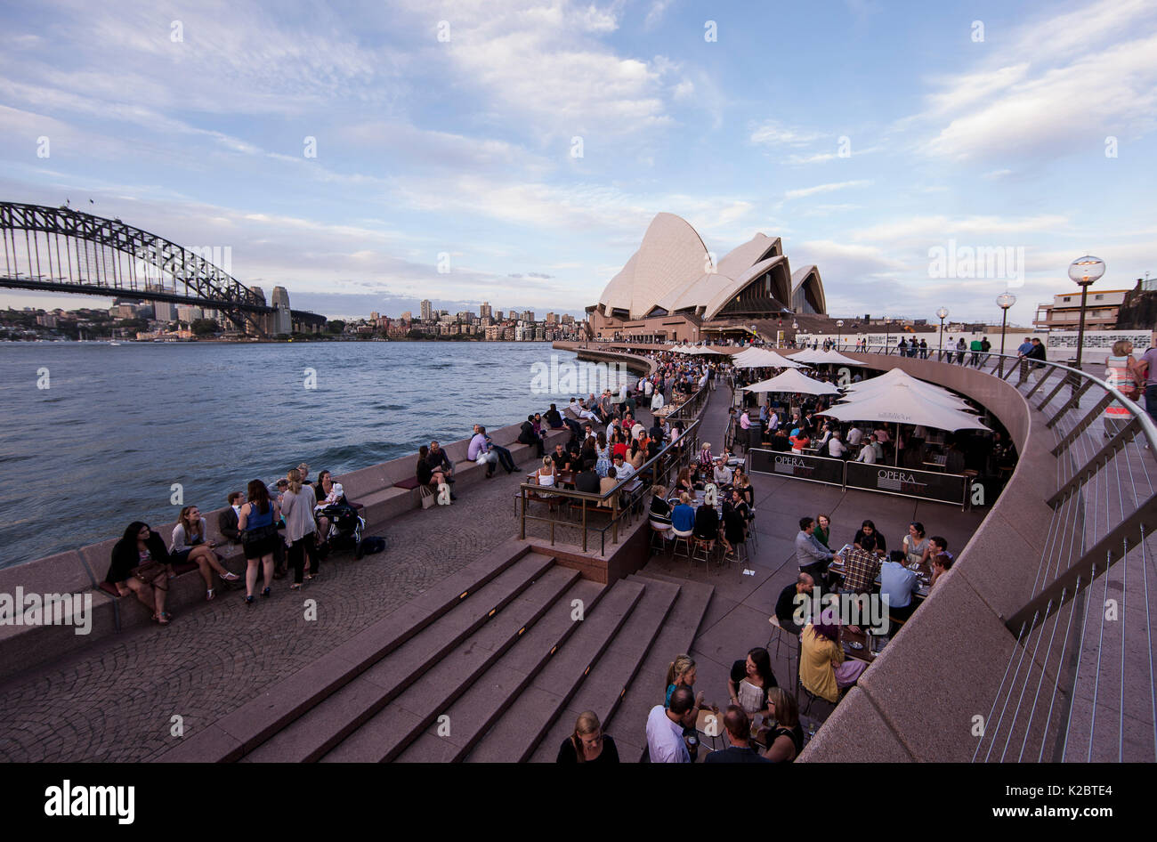 Les gens se détendre dans le port de Sydney, avec vue sur le Harbour Bridge et l'Opera House, New South Wales, Australie. Novembre 2012. Banque D'Images