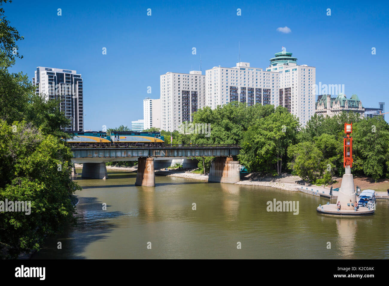 La rivière Assiniboine, un train du CN au lieu historique national de la Fourche à Winnipeg, Manitoba, Canada. Banque D'Images