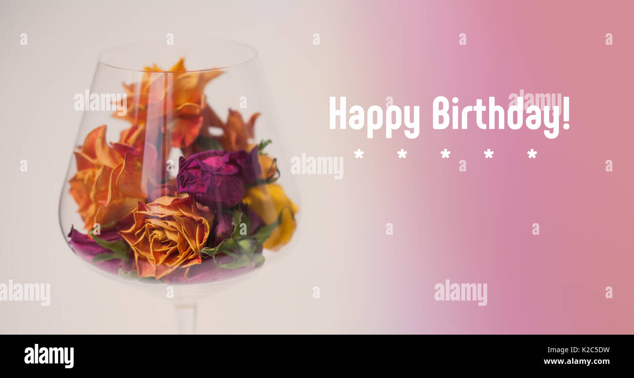 Joyeux Anniversaire Decoration Carte Rose Sechees Fleurs Dans Un Verre De Vin Violet Rose Background Orange Jaune Petales De Fleurs Macro Vision Copy Space Soft Focus Faible Profondeur De Champ Photo Stock