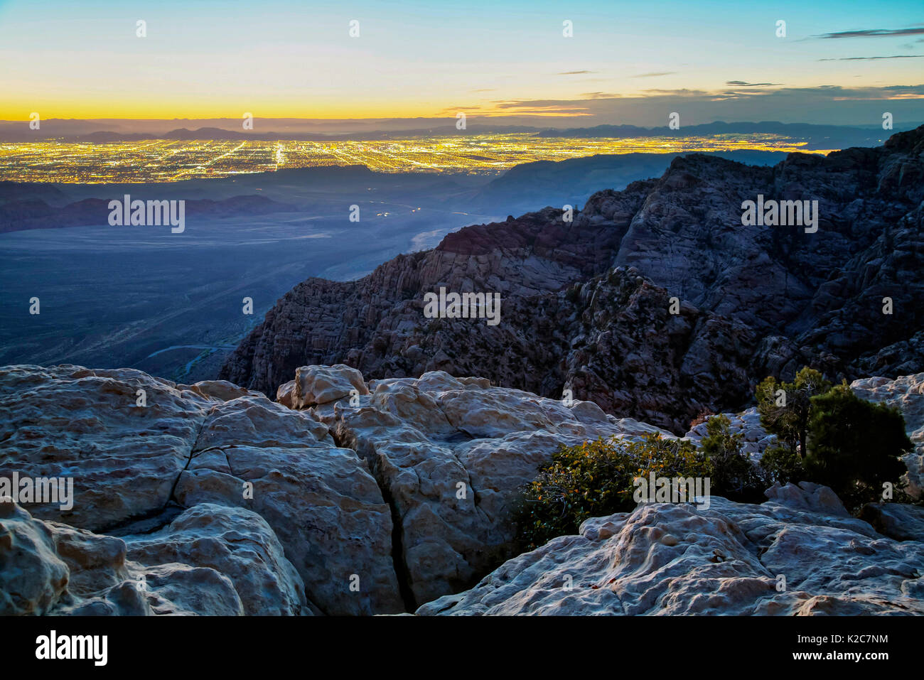 Des formations de roche rouge à l'aube au Red Rock Canyon National Conservation Area avec le Las Vegas lights dans la distance le 27 septembre 2016 près de Las Vegas, Nevada. Banque D'Images