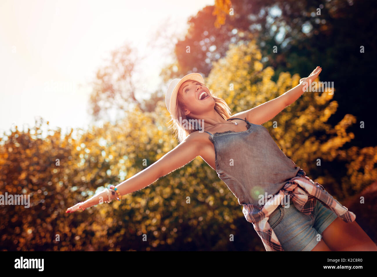 Happy young woman à bras ouverts s'amusant dans la nature en automne. Banque D'Images