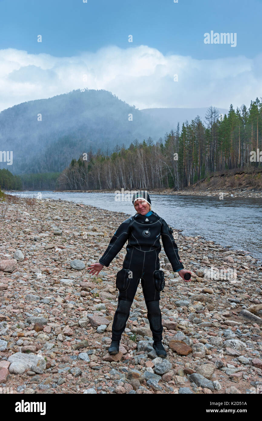 Photographe Olga Kamenskaya wearing wet suit standing next to Temnik River, le lac Baïkal, Baikalsky Réserver, Sibérie, Russie. Mai 2015 Banque D'Images