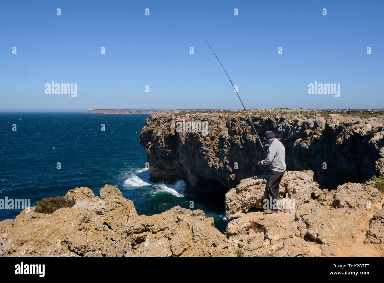 Pêche à la ligne pêcheur dans la mer de l'Atlantique de hautes falaises à Ponta de Sagres, Algarve, Portugal, juillet 2013. Banque D'Images