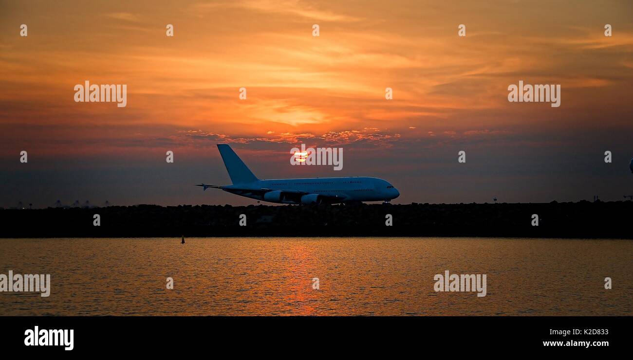 Avions commerciaux, au coucher du soleil, en roulage sur le tarmac de l'aéroport Kingsford Smith sir, mascot, Sydney, Australie. Banque D'Images