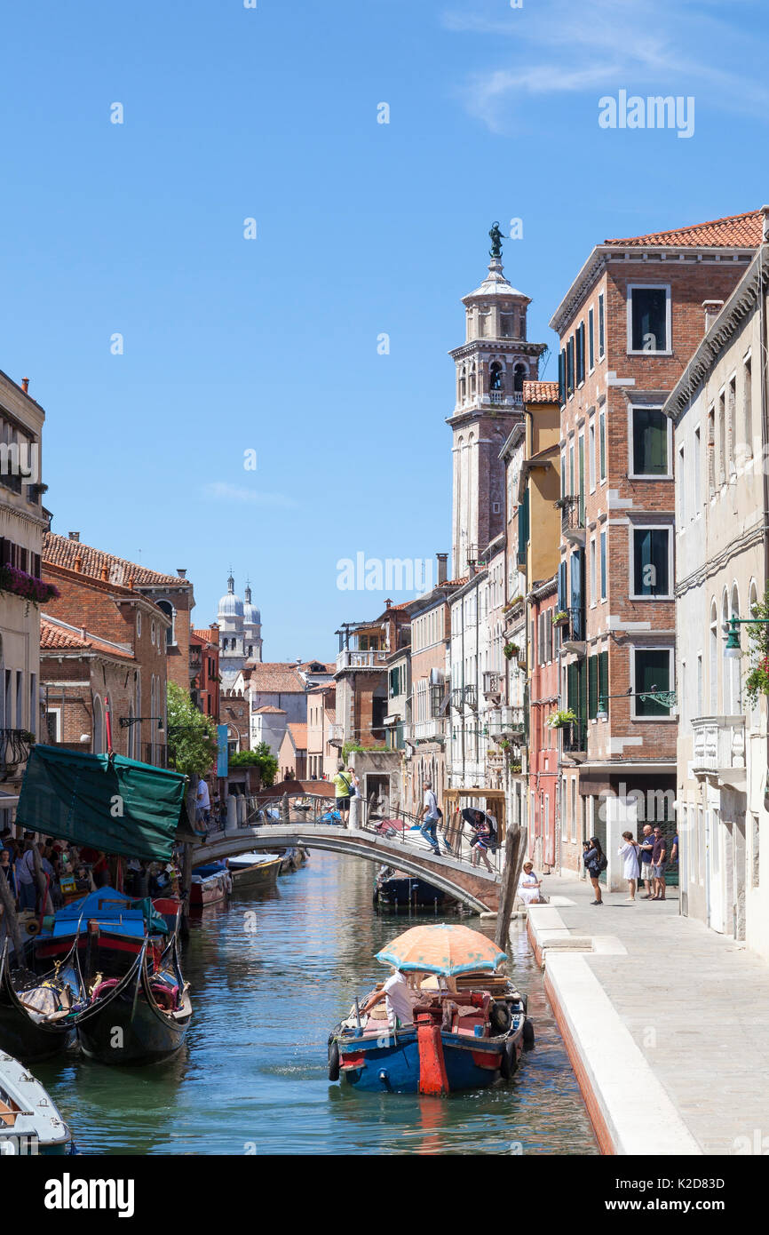 Le pittoresque canal de Rio de San Barnaba, Dorsoduro, Venise, Vénétie, Italie avec gondoles amarrées et un bateau de travail avec unbrella comme protec Banque D'Images