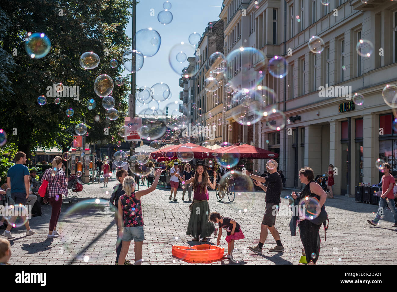 Berlin, Allemagne . 29 août 2017 : Jeune fille faisant des bulles de savon sur une journée ensoleillée sur la rue à Berlin, Allemagne. Banque D'Images