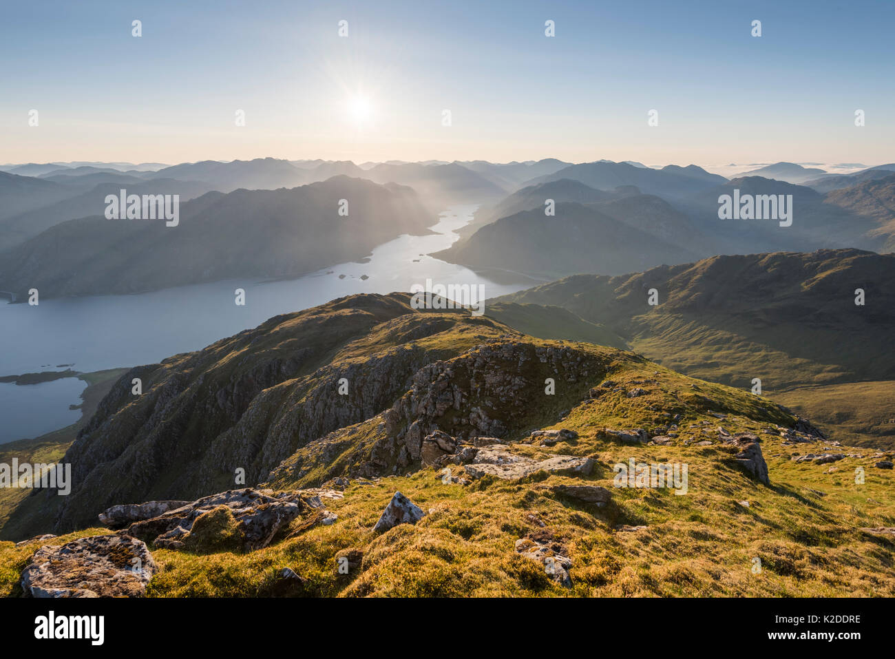 Sunstar et les rayons de lumière sur le Loch Hourn et Barrisdale bay après le lever du soleil. Knoydart, Highlands, Écosse, Royaume-Uni, juin 2016. Banque D'Images