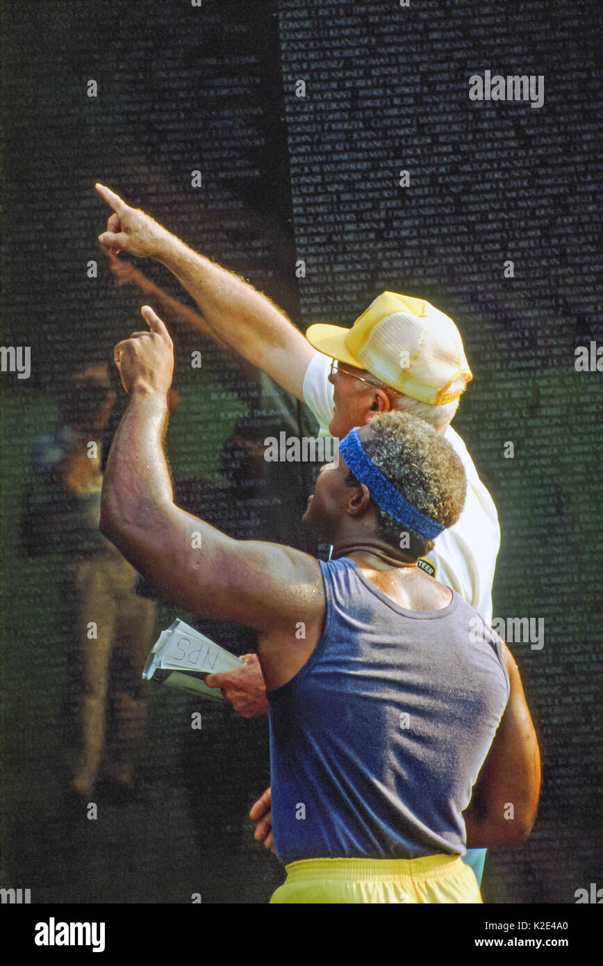 Deux hommes à la recherche d'un nom sur le Vietnam Memorial Wall. Banque D'Images