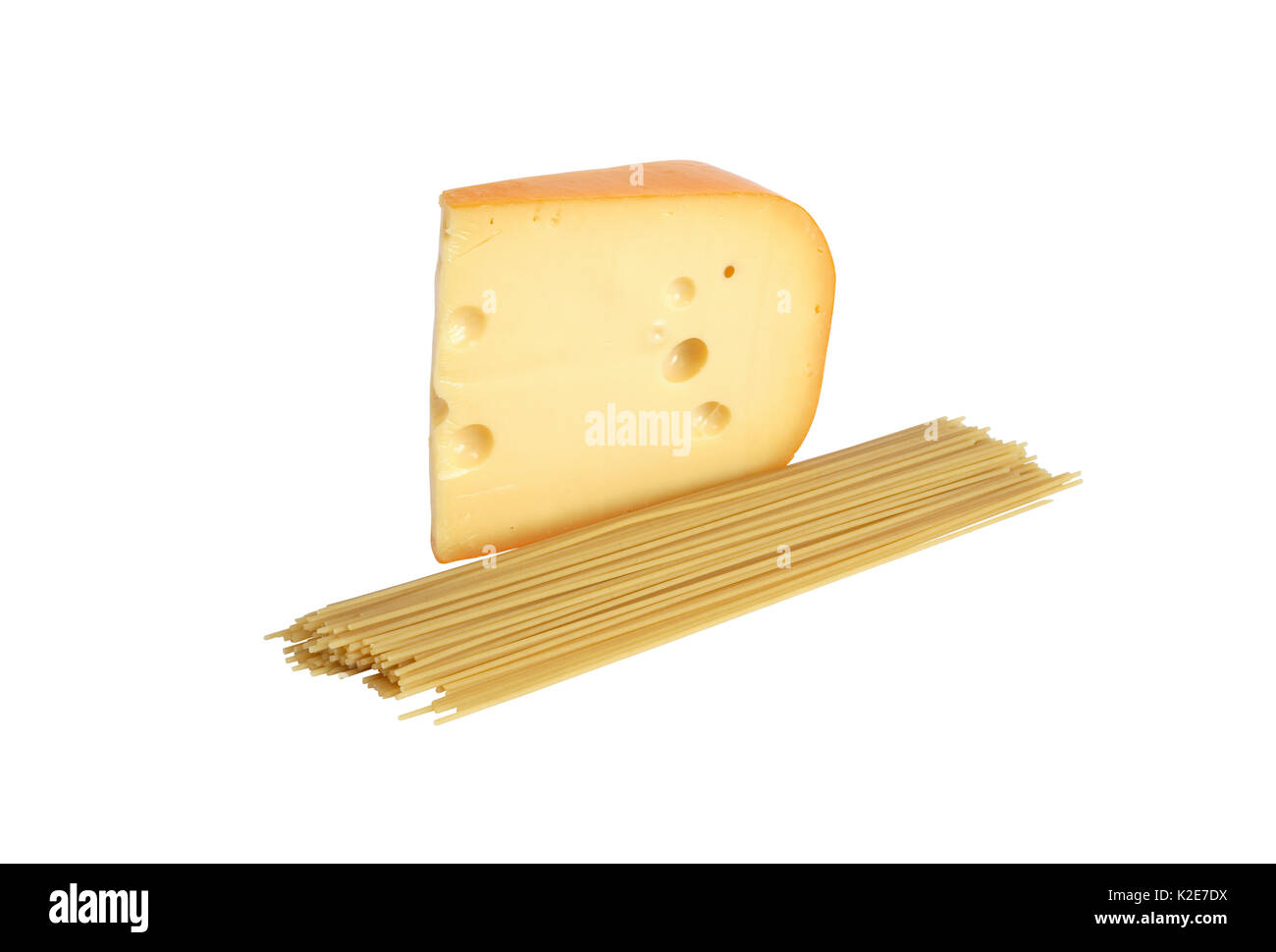 Gros morceau de fromage près de spaghetti crus sur fond blanc. Isolé avec clipping path Banque D'Images