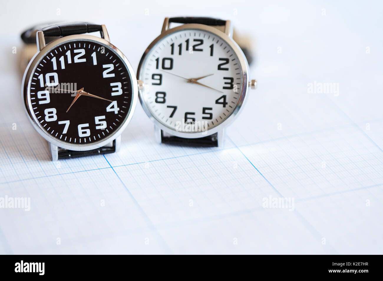 Paire de montres-bracelets modernes debout sur la surface du papier graphique Banque D'Images